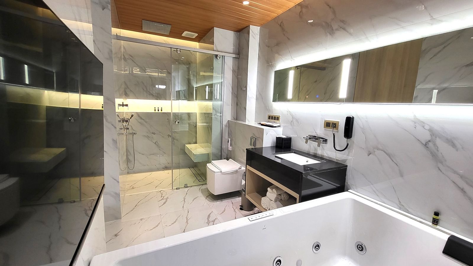 Cropped image of a Jacuzzi and a sink in the washroom in the 6ix sea view room with Jacuzzi at 6ix Seashore Hotel, Port Blair