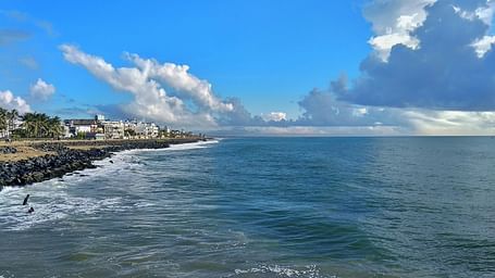An overview of promenade beach with clouds hovering over the waterbody
