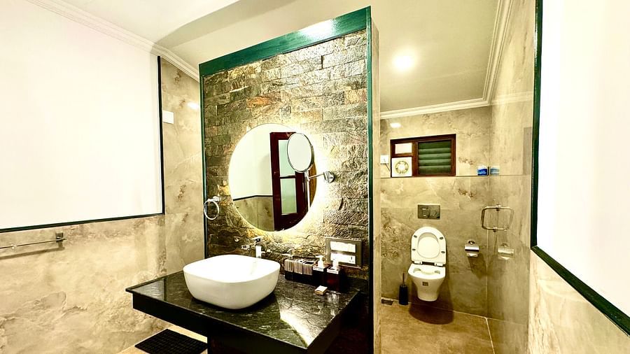 Stylish bathroom with a unique mirror, toilet, and decorative wall art - BluSalzz Collection - Tranquil Resort, Wayanad
