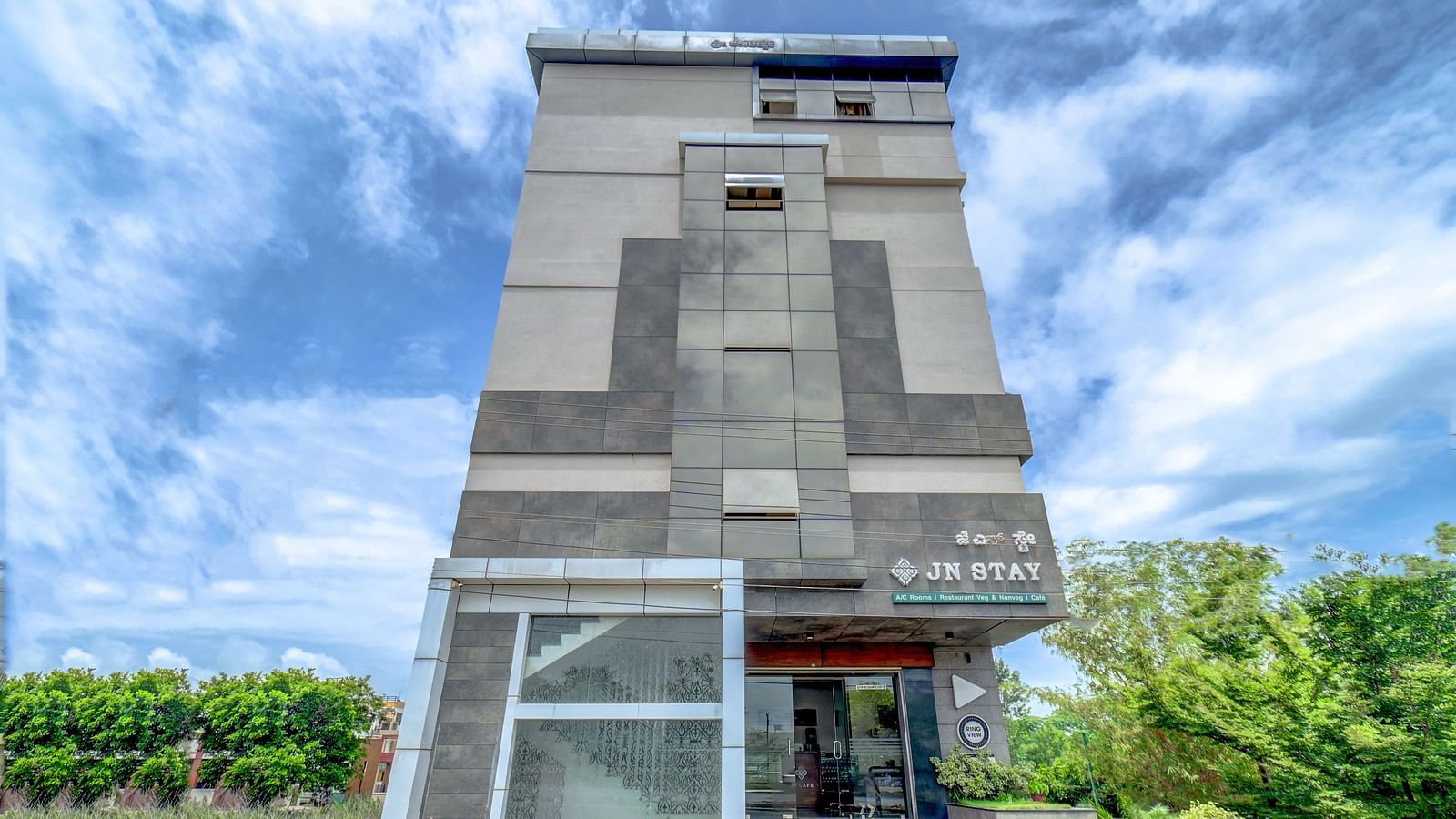 Facade view of Harigovinda's JNStay from the front against a cloudy sky