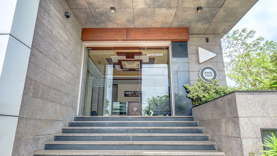 Entrance of Harigovinda's JNStay with stairs leading to the glass door