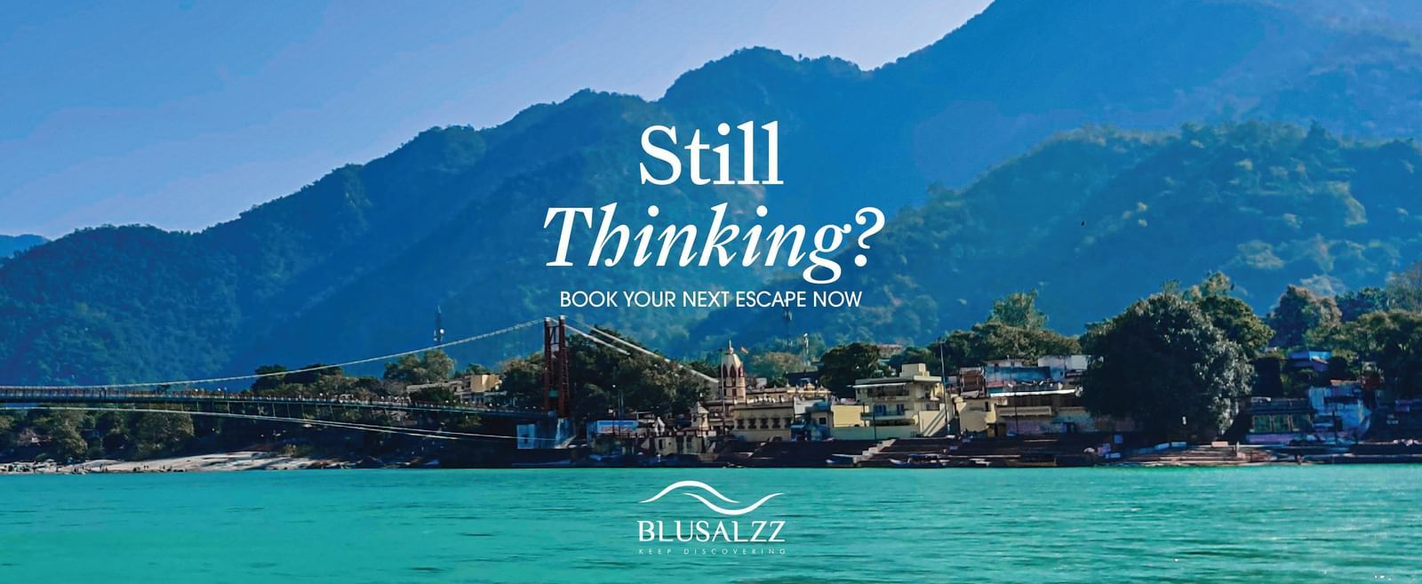 Scenic riverside town with mountains in the background, bridge over turquoise water, and 'Still Thinking? Book Your Next Escape' text.