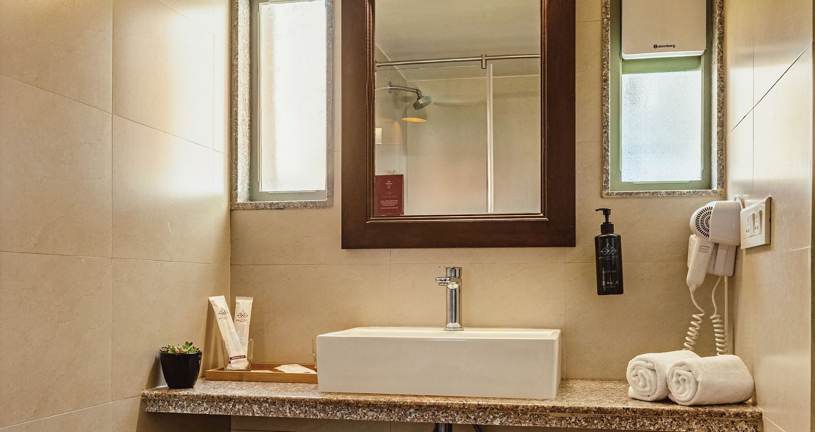 Well-organised bathroom at Mango Hill Shola, Ooty, equipped with a sink, wall mirror, and toilet, designed for a comfortable guest experience.