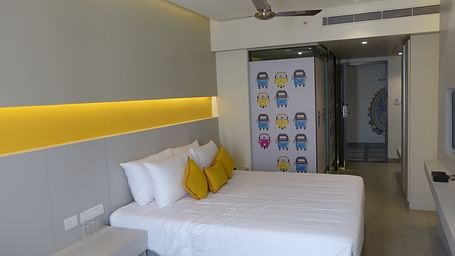 Spacious twin beds with headboards stretch across the wall with door way leading to the  next room