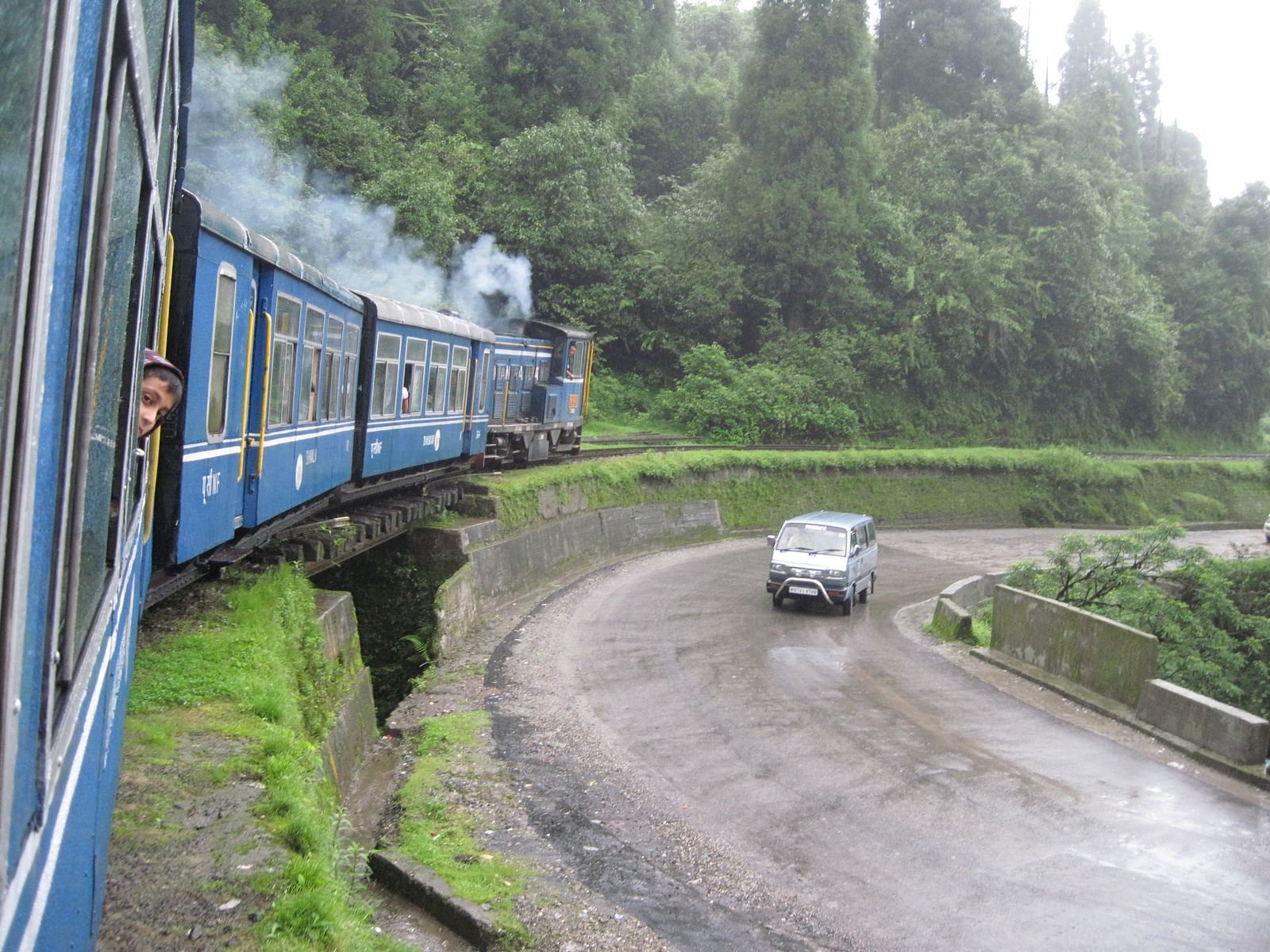 a passenger looking out from the window of a toy train in Darjeeling
