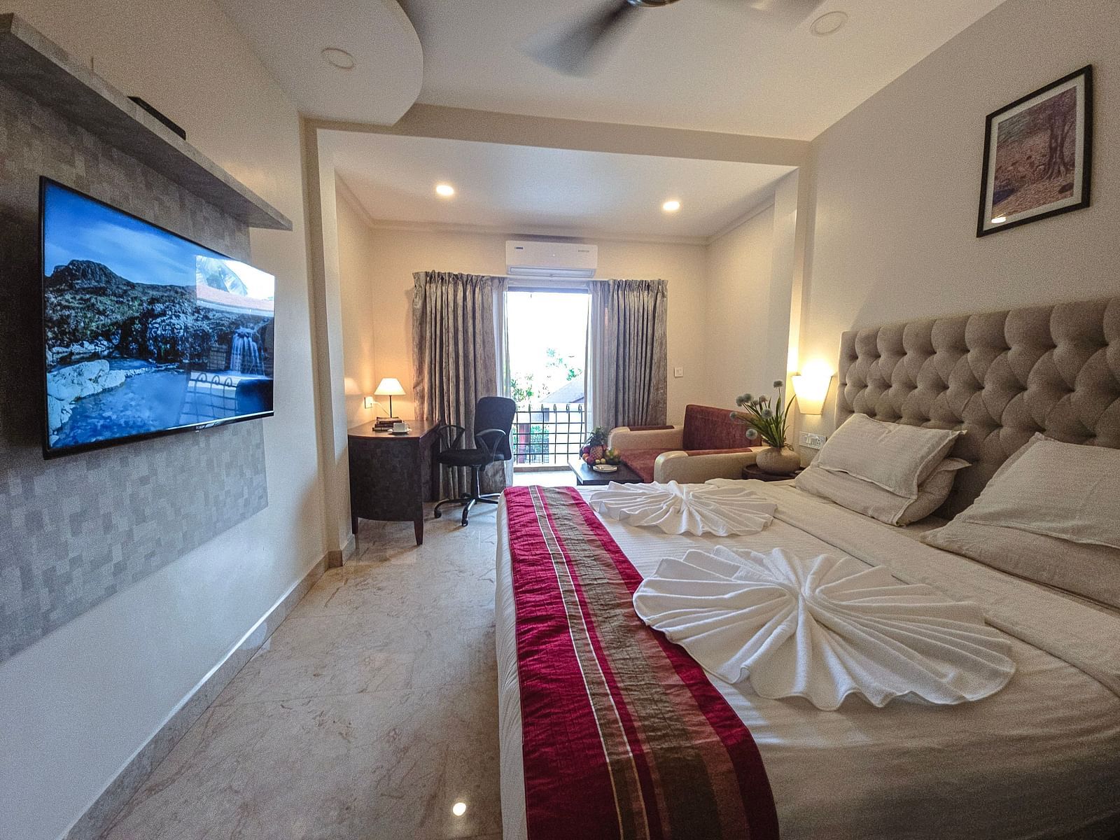 A bright room with an elegant bed, seating area, and access to a balcony – The Verda de Miranda Resort.