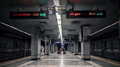 Platform inside a Kolkata Metro station with digital train information displays.