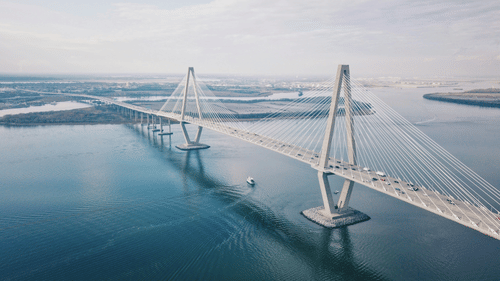 A hanging bridge connecting two lands separated by the sea, with the sky in background