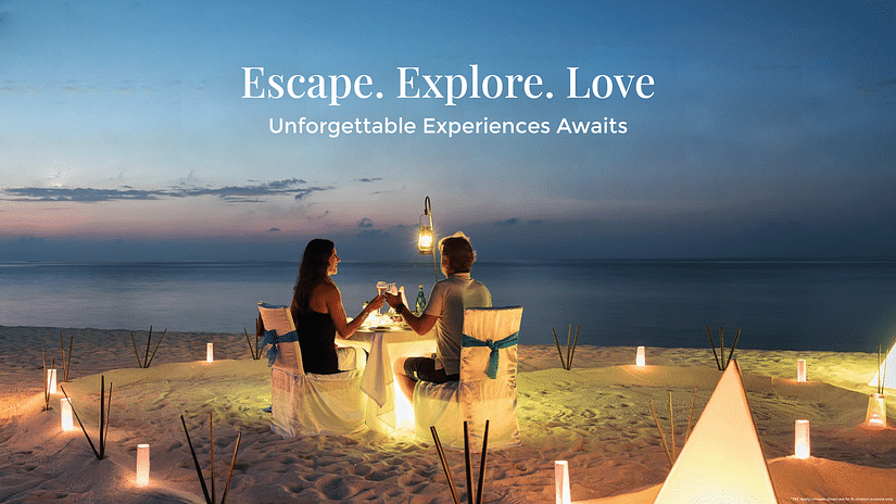 Romantic Getaway Banner featuring a couple having candlelight dinner on the shore while relishing the sunset as the text says Escape. Explore. Love. Unforgettable Experience Awaits.