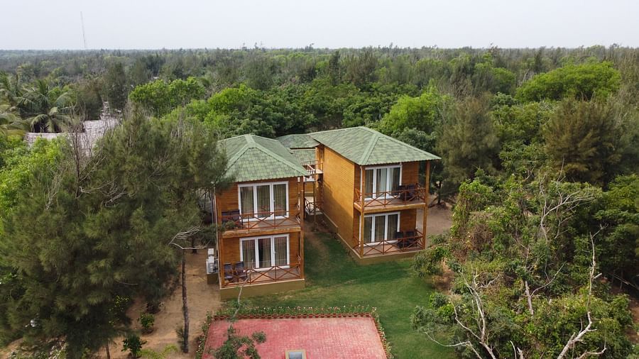  Far  aerial view of a charming twin villa with green roofs, expansive balconies, and surrounded by lush foliage, nestled in a serene environment-Lotus Eco Beach Resort Konark 