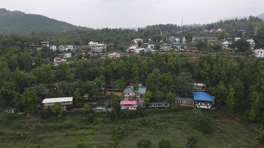outside panoramic views with hills in the distance and  lots of scatteed houses among trees.