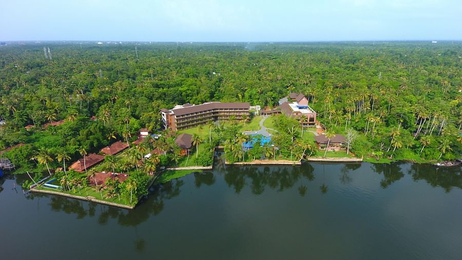 Uday Backwater Resort seen amidst the lush greenery under a clear sky