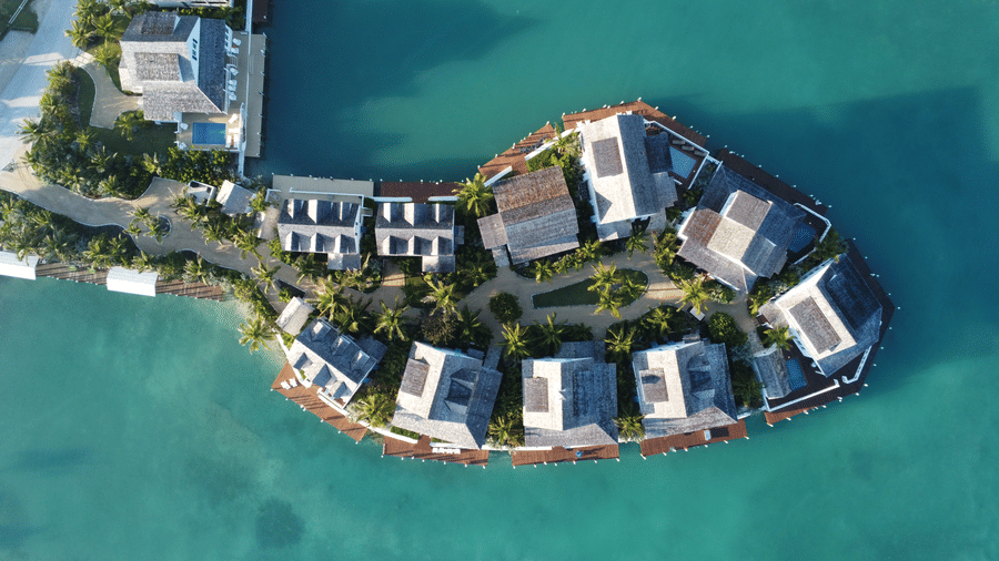 Scenic aerial of Sunset Point by Abaco Inn, highlighting turquoise waters, modern villas, and tropical landscaping in a luxury coastal environment.
