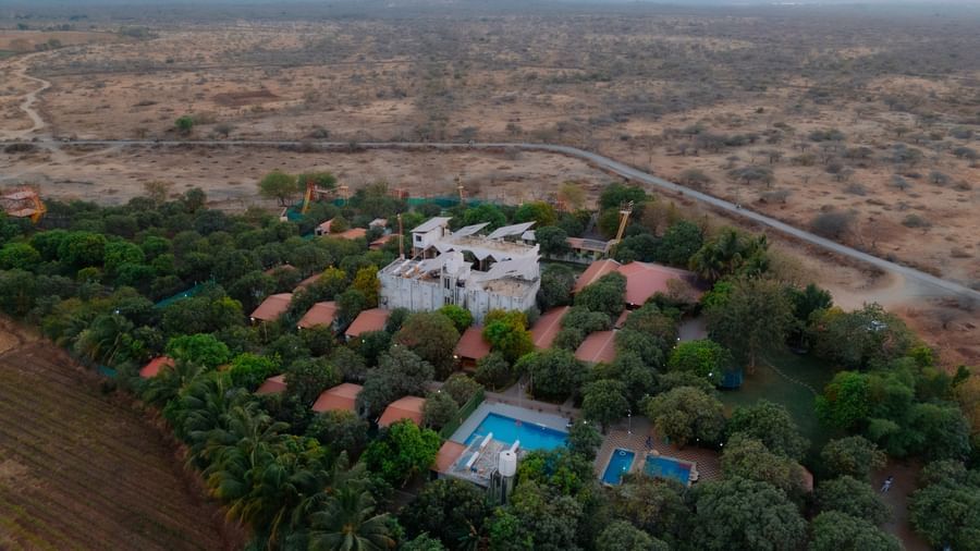 An aerial view of Daksh Resort and Amusement Park, featuring cottages and buildings surrounded by greenery.