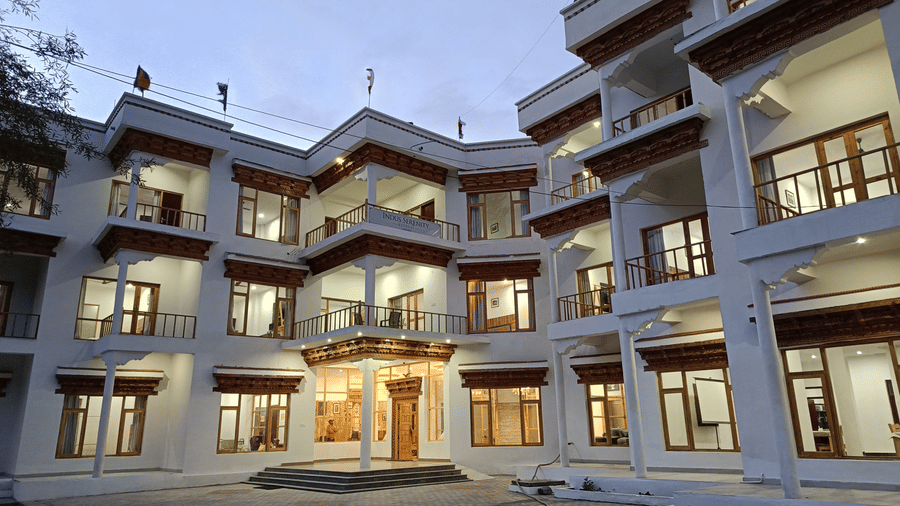 Close-up exterior shot of Indus Serenity Retreat highlighting the elegant balconies, large windows, and warm ambient lighting at night.