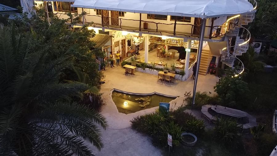 Overhead view of outdoor area with a pond at twilight, surrounded by lush greenery | Matsya Island Retreat