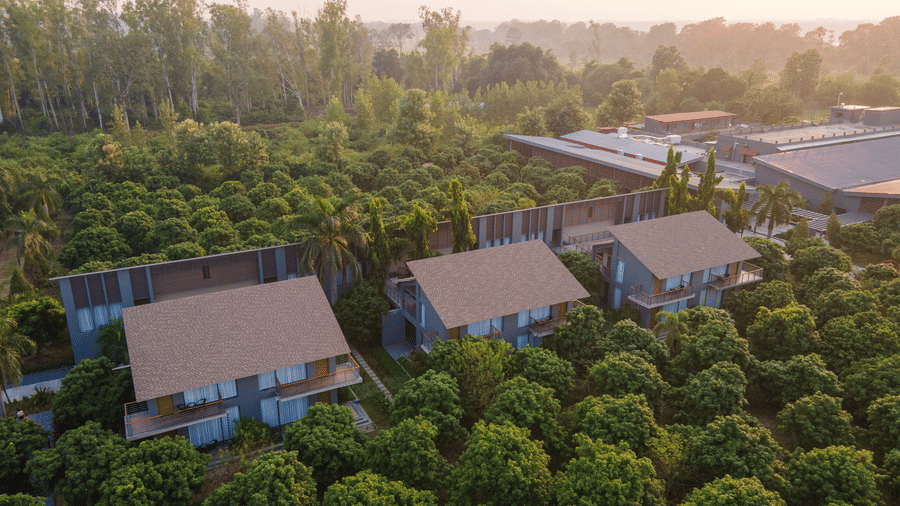 An elevated view of a row of sloped-roof resort villas at Wyndham Garden surrounded by low-lying trees.