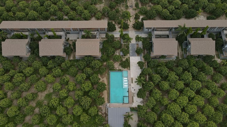 Aerial view of the Wyndham Garden surrounded by lush greenery with a central turquoise pool and villa-style accommodations.