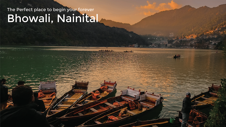 Boats on the deck of the lake in Nainital with mountains in the background as the dusk around the corner and the text says 'The perfect place to begin your forever - Bhowali, Nainital'