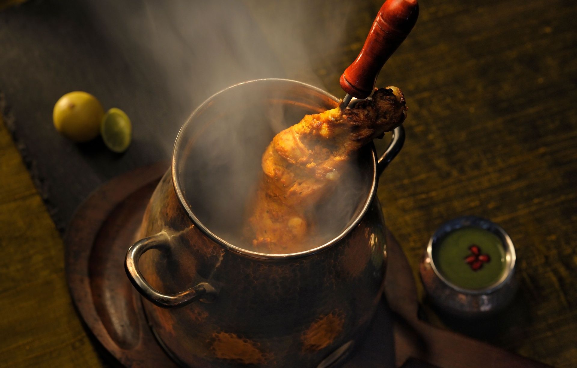 Steaming chicken leg with lemon and green chutney.