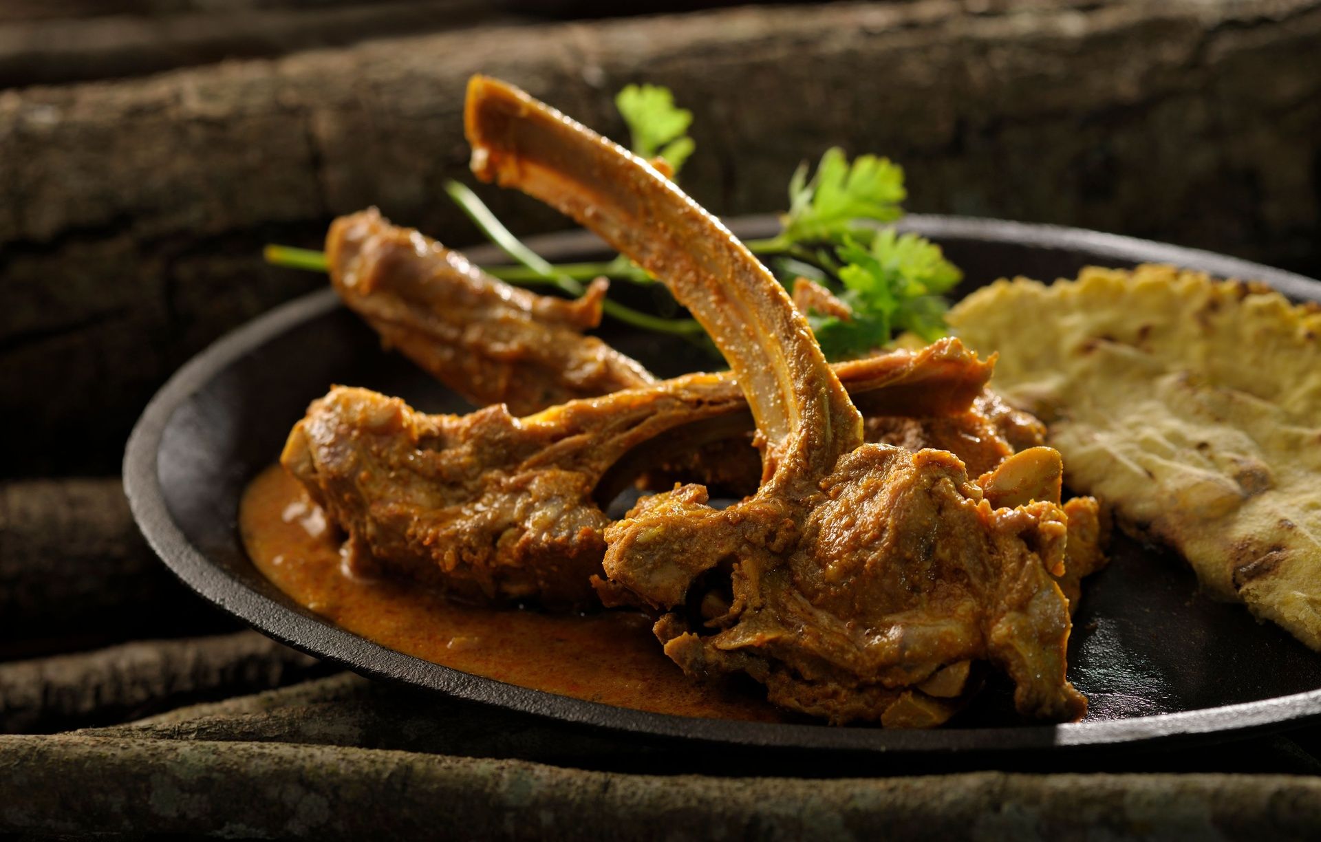 Mutton chops curry with flatbread and cilantro.