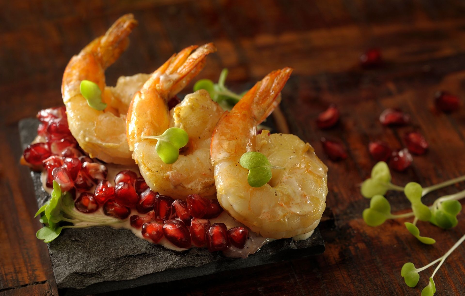 Cooked shrimp with pomegranate and microgreens.