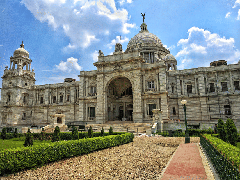 The pathway to the Victoria Memorial surrounded by lush well manicured lawns.