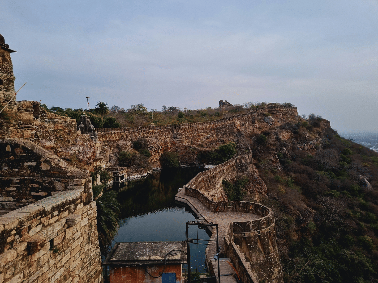 Hilltop Rajasthani fort with stone ramparts and water reservoir