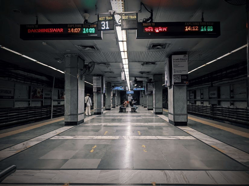 Platform inside a Kolkata Metro station with digital train information displays.