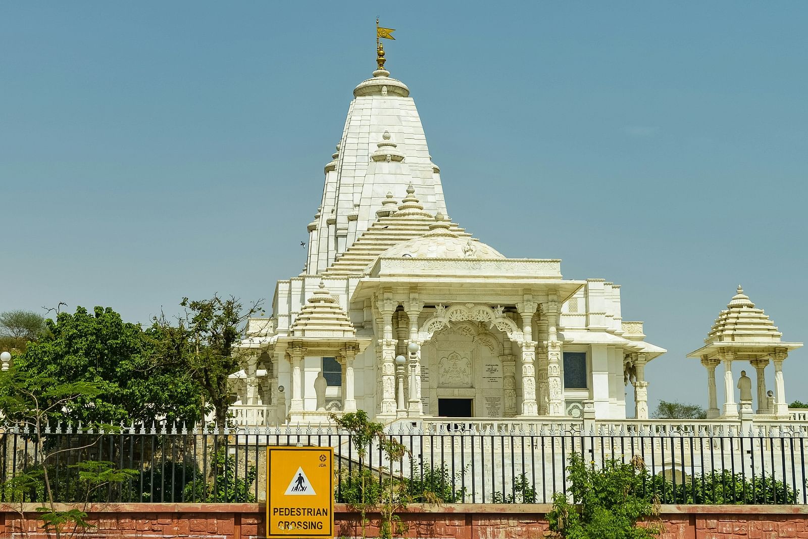 a daytime shot of the front of a large temple with white colours