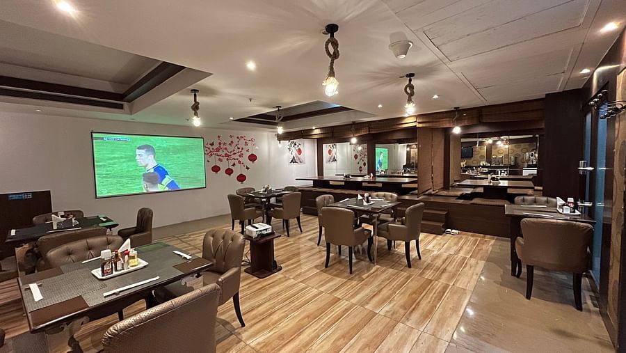 restaurant area at Yuhi Mansions showcasing 100 22 LED screen for live sports telecast along with spacious indoor seating arangement1