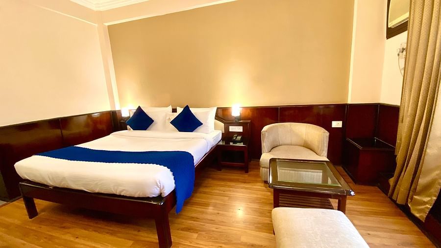 A bedroom with warm lights illuminating each side of the bed at DLS Park Grace, Haridwar.