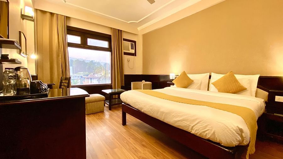 A room with a king size bed and multiple pillows at DLS Park Grace, Haridwar.