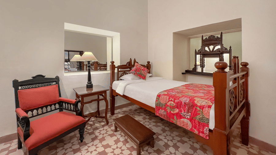 A room with a single bed, a chair, a small table, and a bench in Tijara Fort-Palace - 19th Century, Alwar.