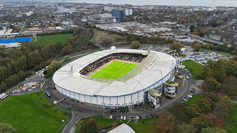 An aerial view of a football stadium with the city in the backdrop