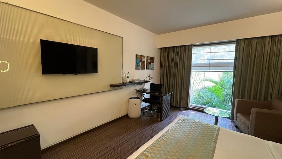 side angle view of bedroom with white linens soft pillows. room amenities and large curtined window2 - yuhi mansions