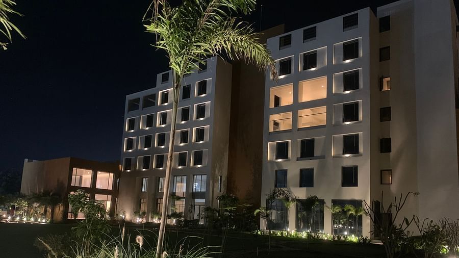 A dutch night view of the facade of Pride Resort Ambaji with some trees in the picture around it