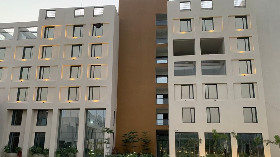 A front view of the facade of Pride Resort Ambaji with some trees in the picture around it