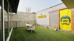 Outdoor seating area at Nemesia with lush greenery and a vibrant mural.