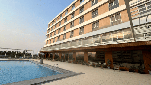 facade of VITS Satyajeet Karad with a swimming pool in front of it