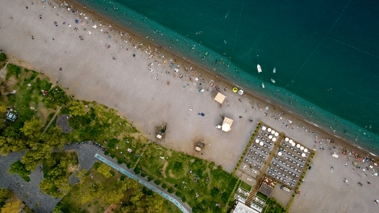 Top-down view of a sandy coastline meeting turquoise ocean water.
