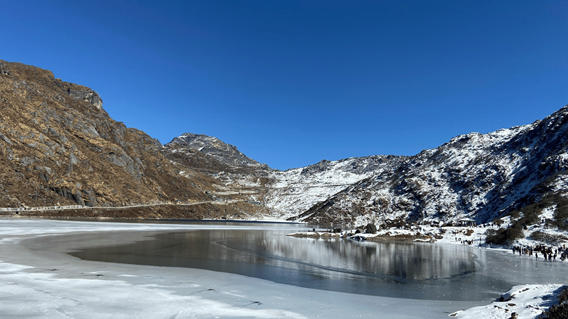 Tsomgo Lake, one of the best places to visit during Gangtok sightseeing, under a clear sky surrounded by mountains