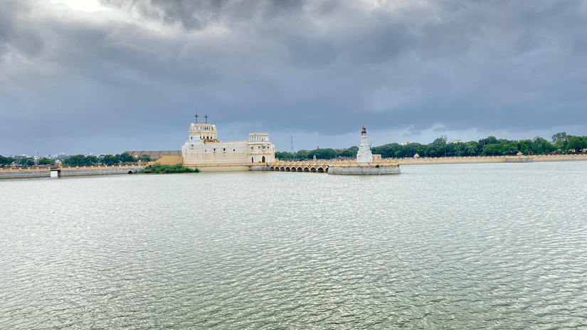 Scenic lake view of the Lakhota Fort and Museum surrounded by water under cloudy skies