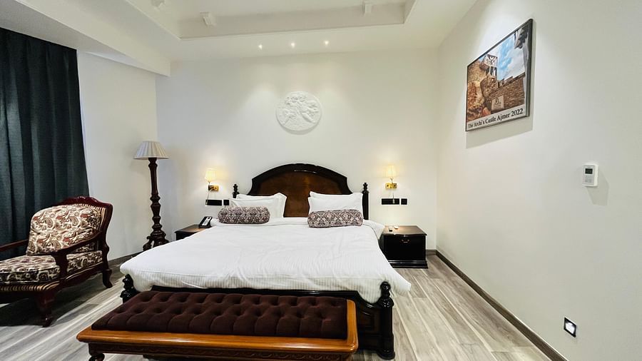 an image of a bedroom with a chair and a painting at Clarks Resort The Archi’s Castle, Ajmer