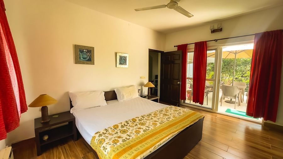 A king bed with access to balcony at el benito goa