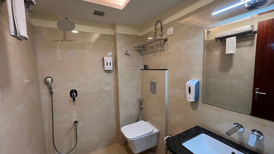 An image of a washroom featuring sink, faucet, handwash, mirror on the wall, showerhead, towel, and jet spray at Five Elements Hotel, Jodhpur
