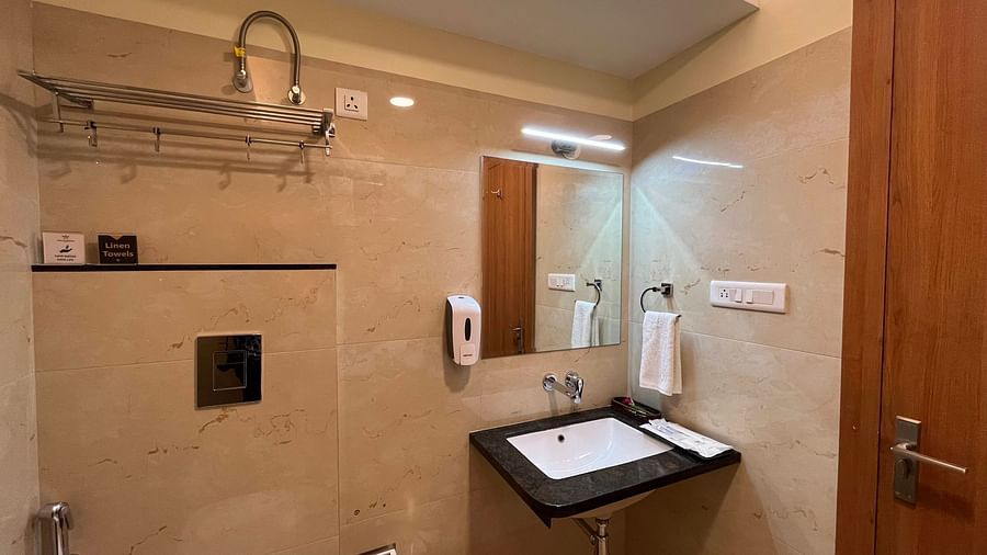 An image of a bathroom at Five Elements Hotel, Jodhpur featuring essential elements like sink, faucet, cloth holder, towel, and mirror on the wall