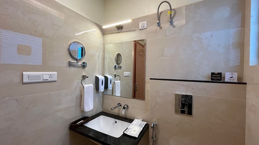 An image of a washroom featuring bathroom amenities like sink and faucet, showerhead and jetspray, and a towel at Five Elements Hotel, Jodhpur
