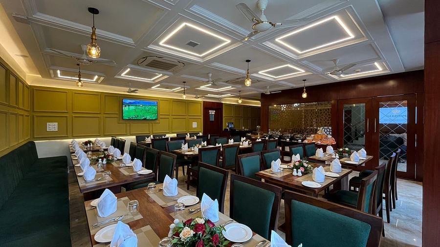 An image of a dining table where several plates, cutlery, and napkins are placed at Five Elements HOtel, Jodhpur