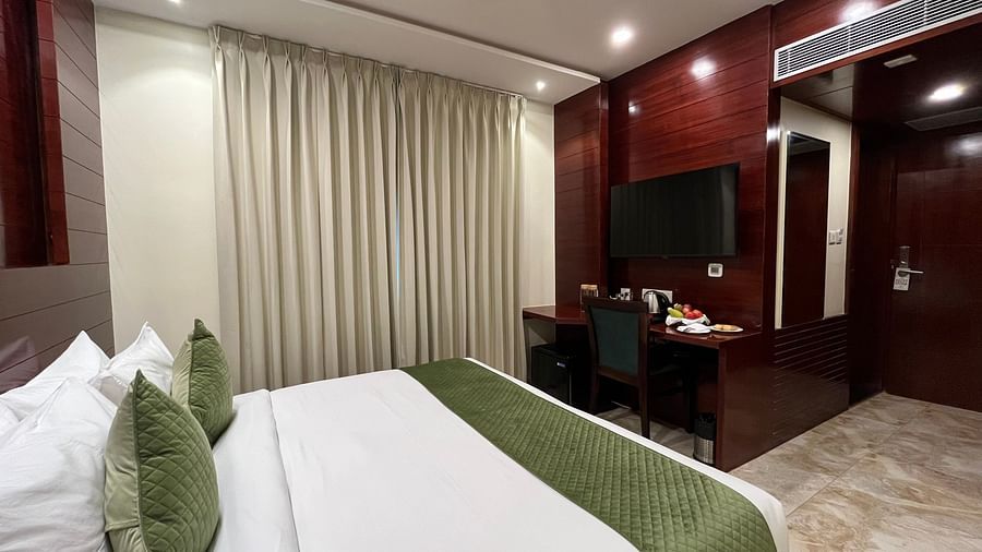 An image of a bedroom with a tea and coffee maker, a work desk and chair, and a flat TV screen at Five Elements Hotel, Jodhpur